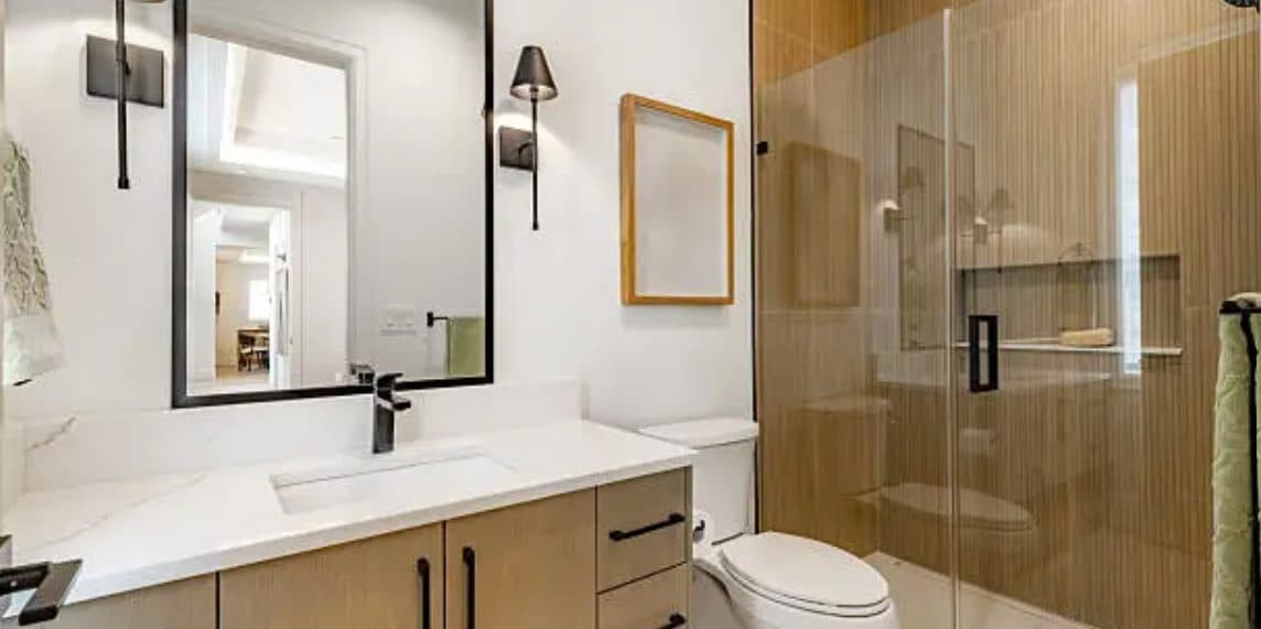 Recently completed HN Construction bathroom with floating wood vanity, framed mirror, and walk-in glass shower