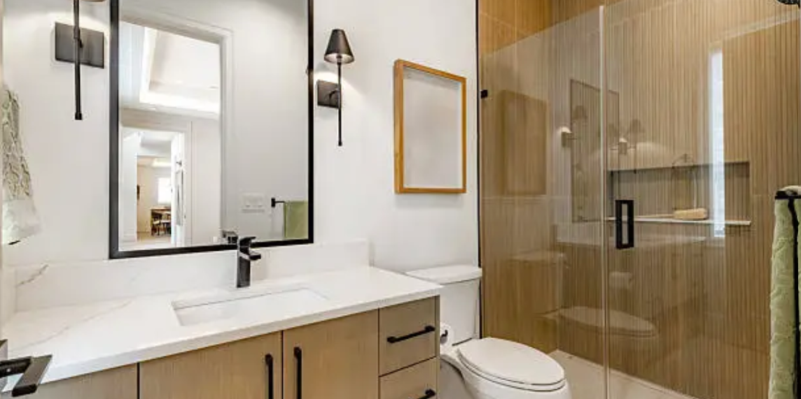 Modern Plano bathroom with floating wood vanity, framed mirror, and glass walk-in shower